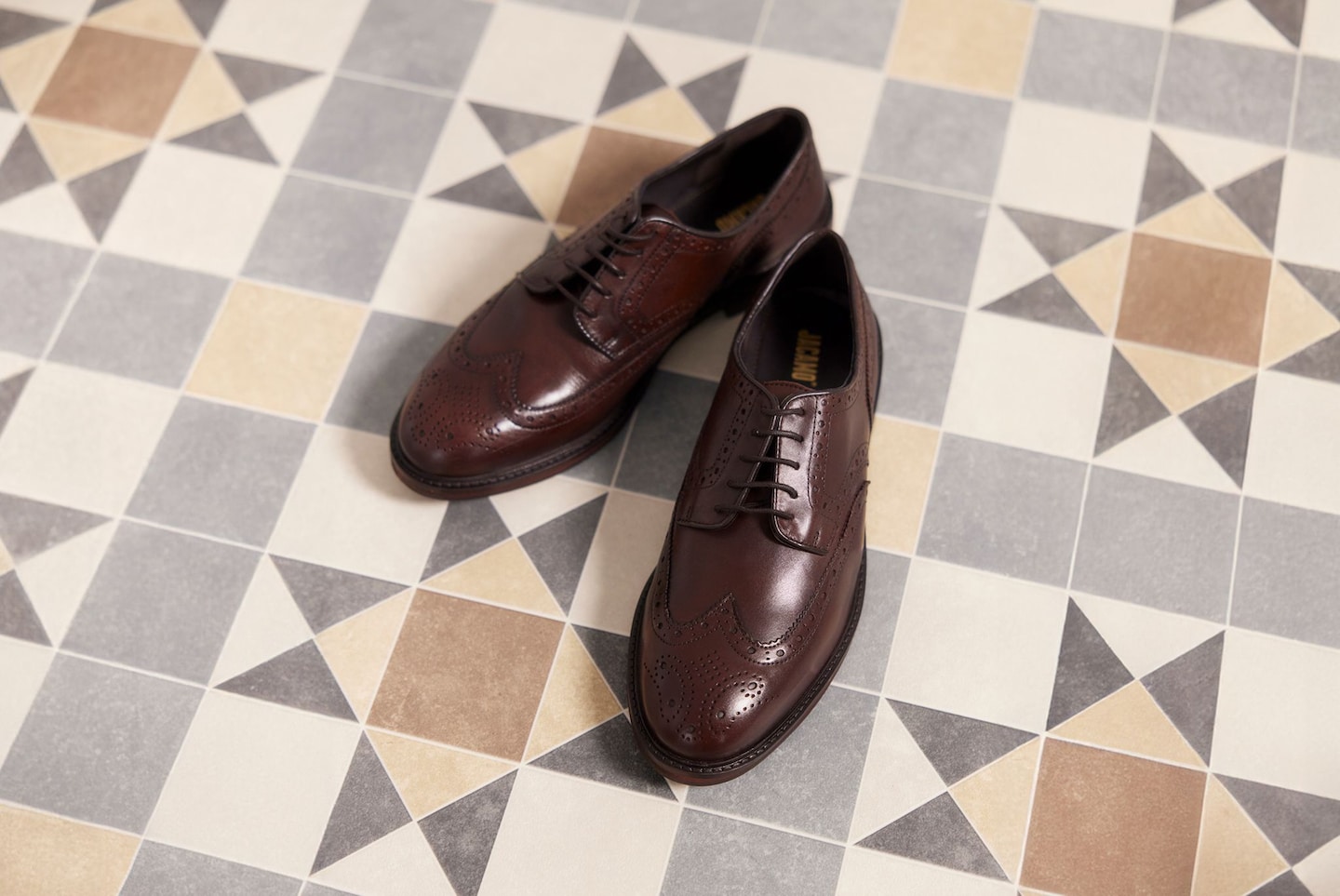 Brown smart shoes displayed on tiled floor