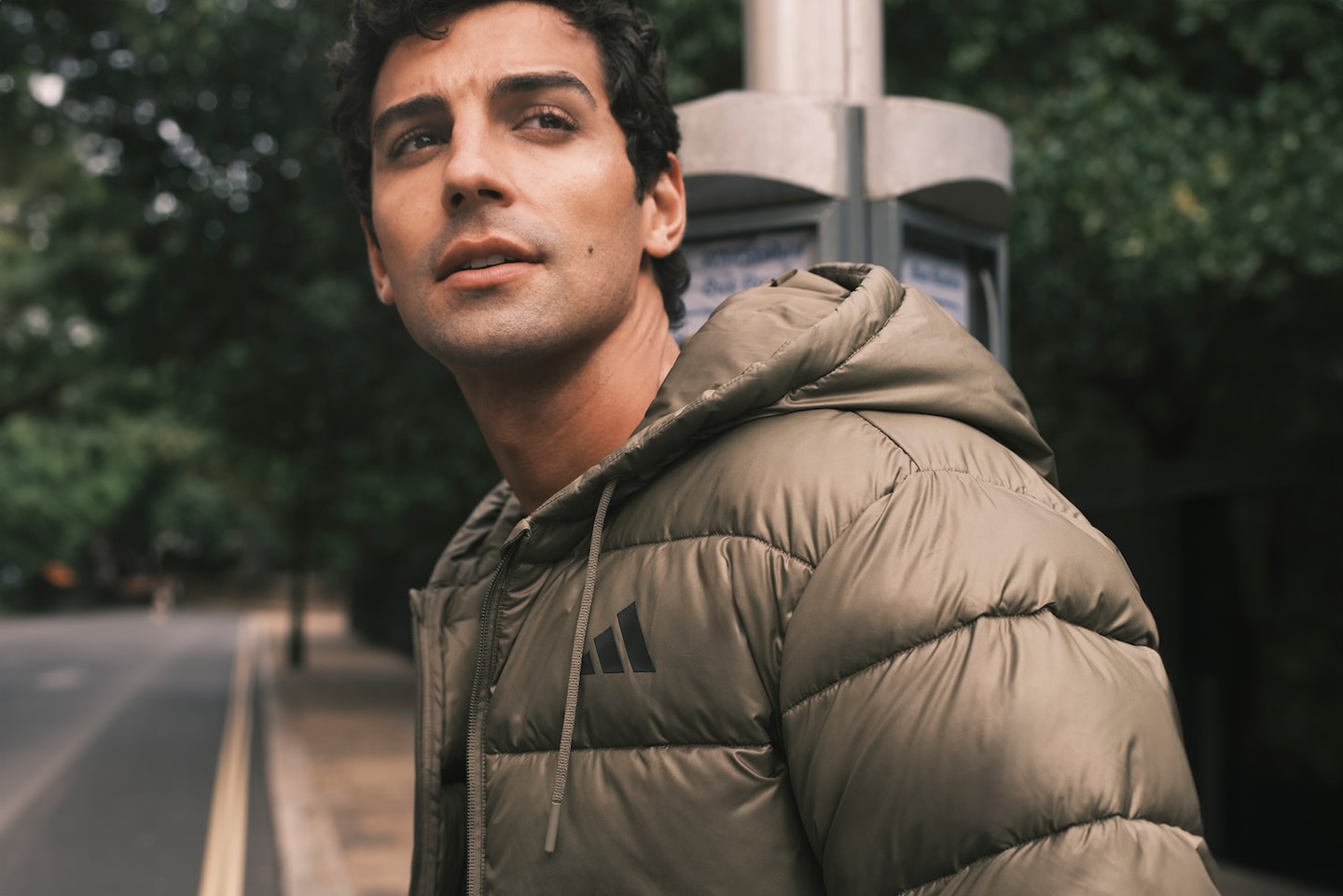 Model wearing a khaki green adidas puffer jacket