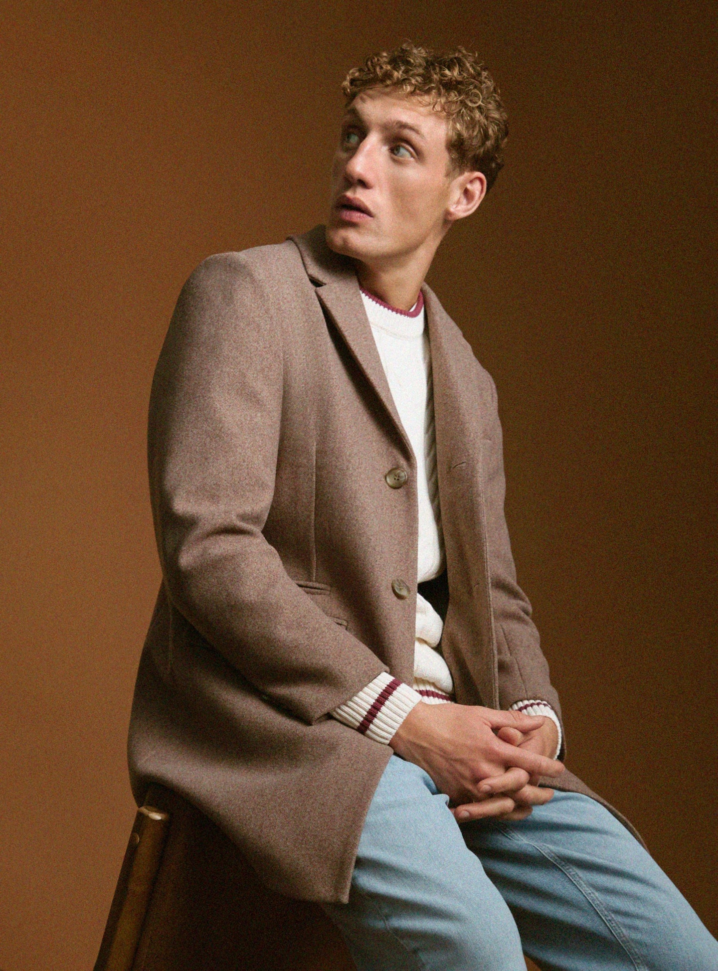 Model wears sat wearing smart brown jacket and jeans