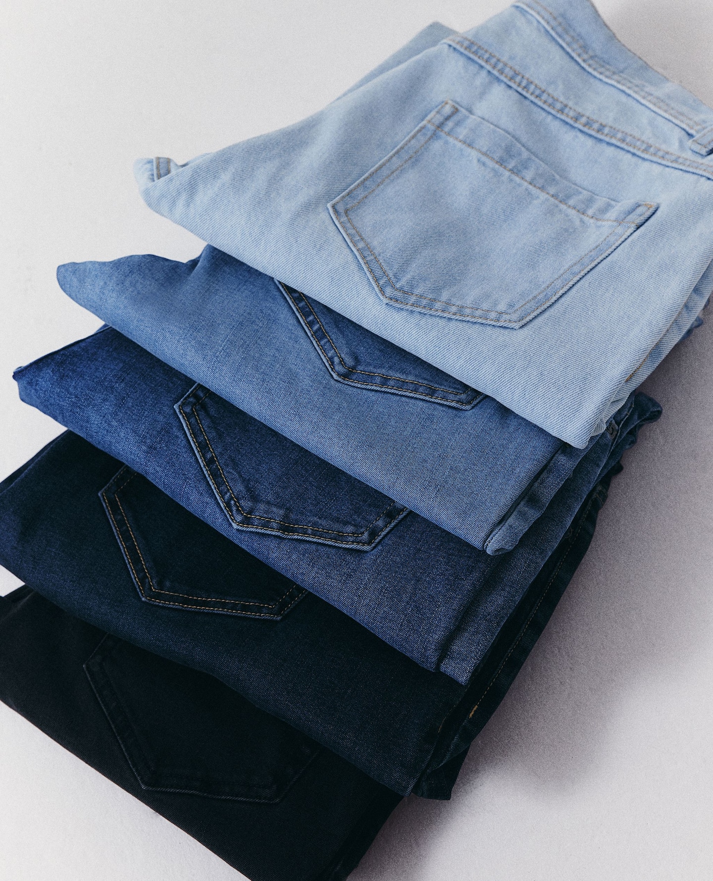 Jeans arranged in a row, various colours or washes