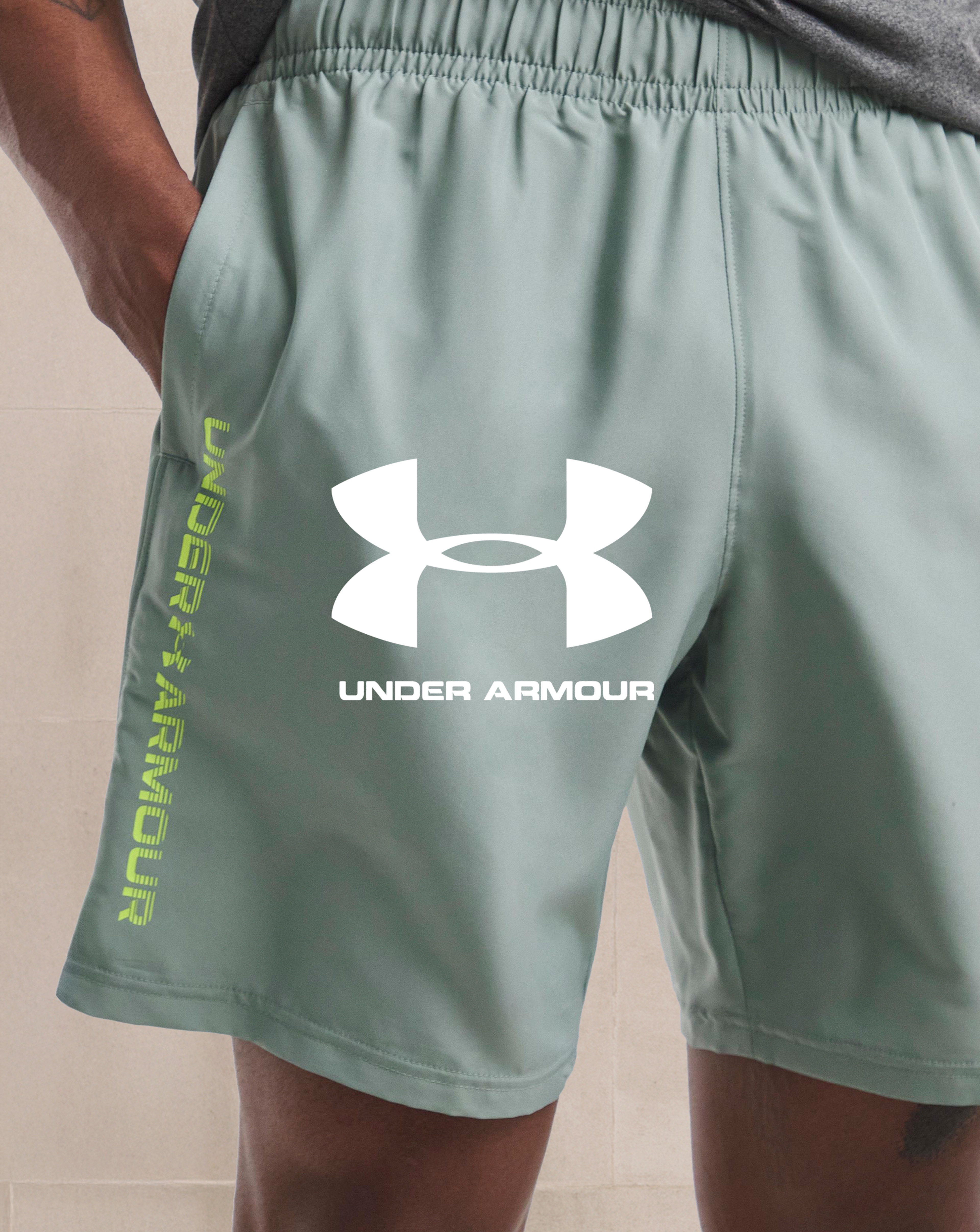 Under Armour. Model wears Under Armour Tech Woven Wordmark Shorts