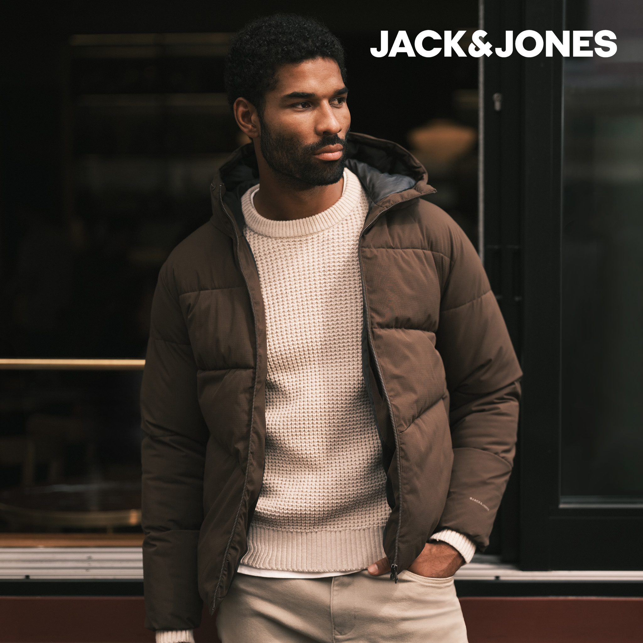 Model wearing a cream knitted jumper with a khaki Jack & Jones puffer jacket
