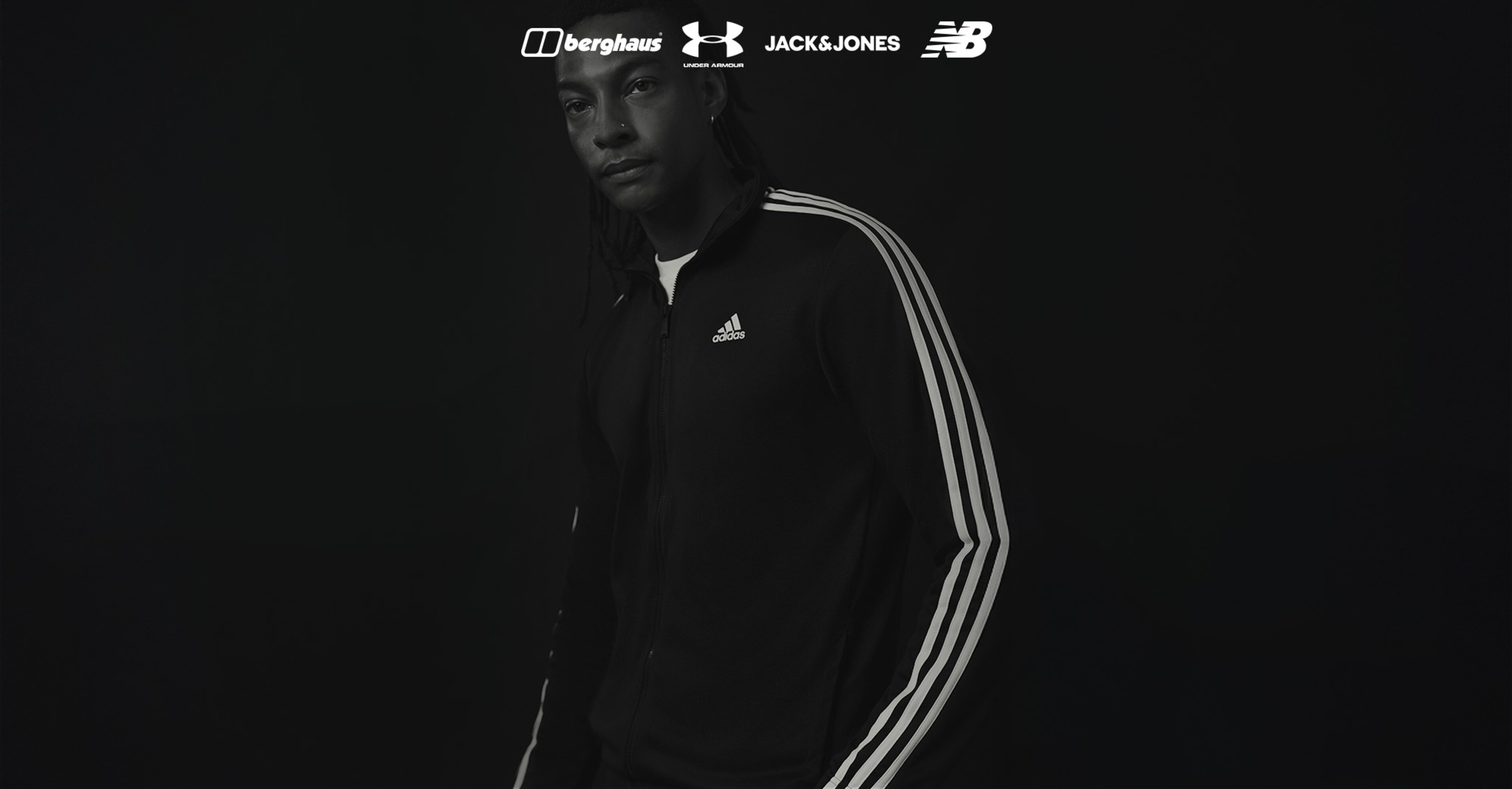 A black and white image of a model wearing an adidas tracksuit 