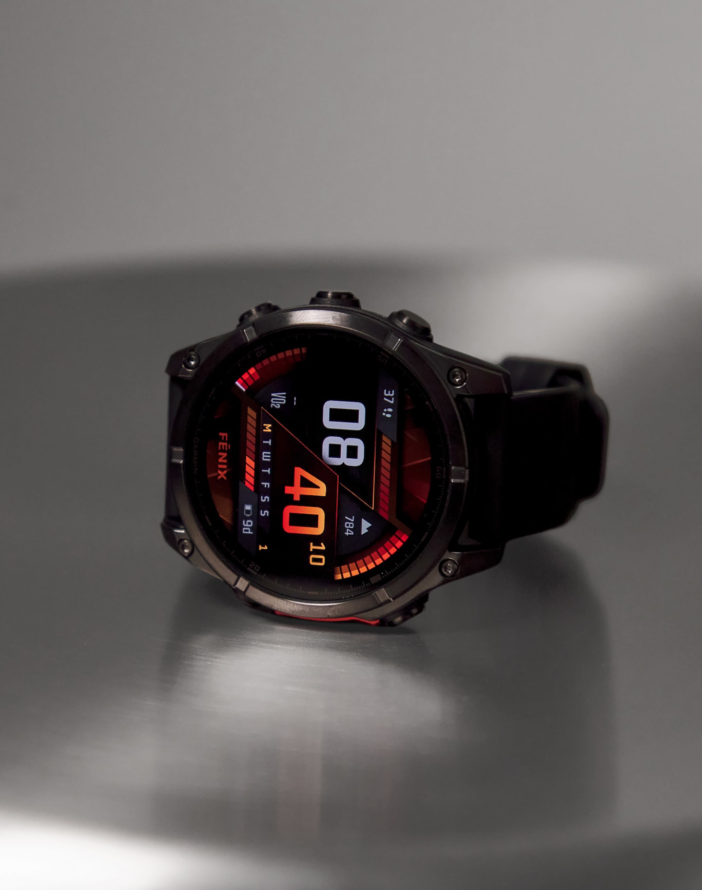 A smart watch lay on its side on a shiny surface